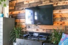 65 a weathered and stained wood accent wall softens the industrial-inspired living room with vintage touches