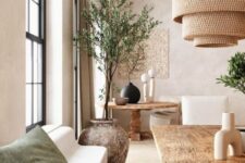 71 a lovely neutral space done with a lot of texture, with a stone bench, a rough wood dining table and a round one, a plant in a shabby chic stone planter and woven lamps