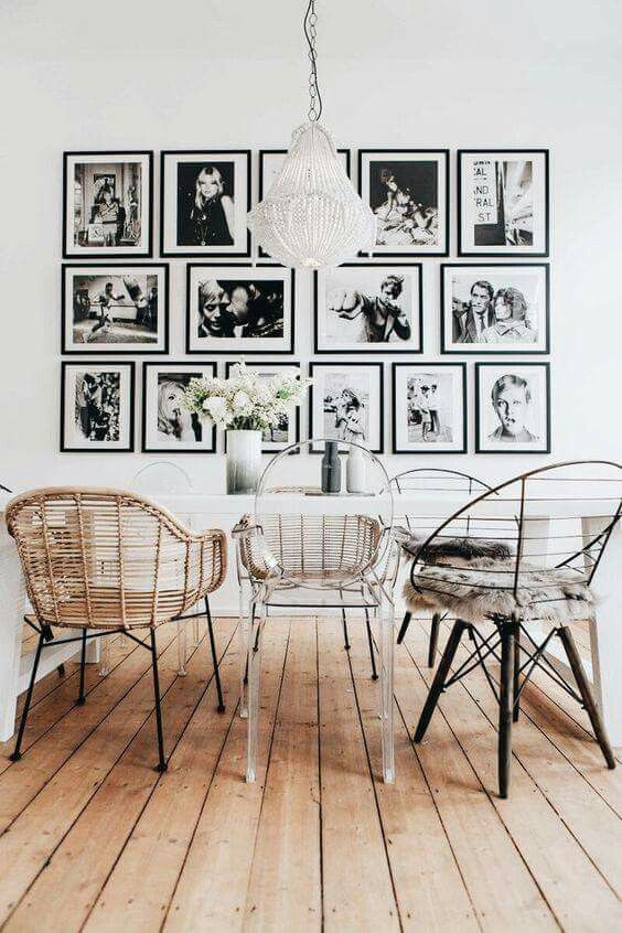 a Scandinavian dining space with a white table, mismatching chairs including a ghost one, a black and white gallery wall