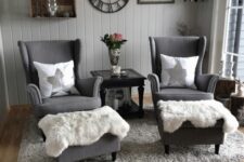 a Scandinavian sitting space with grey walls, box shelves, grey Strandmon chairs, ottomans, a grey rug and faux fur plus some decor