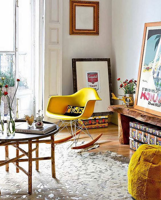 a bright mid-century modern space with a living edge bench, a  yellow Eames rocker, an Easten style coffee table and some artwork