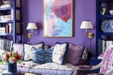 a bright whimsical interior with a purple accent wall, violet bookcases, floral print seating furniture and glass coffee tables