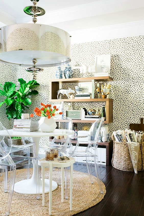 a bright working space with a spotted walls, a stained shelf, a round table, ghost chairs and a catchy pendant lamp