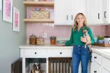 a catchy pink and white kitchen with shaker cabinets and built-in dog kennels is a cozy and cute space