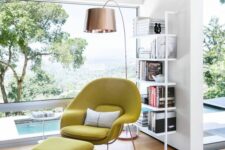 a catchy reading nook with a panoramic window, an airy bookshelf, a mustard Wumb chair and ottoman