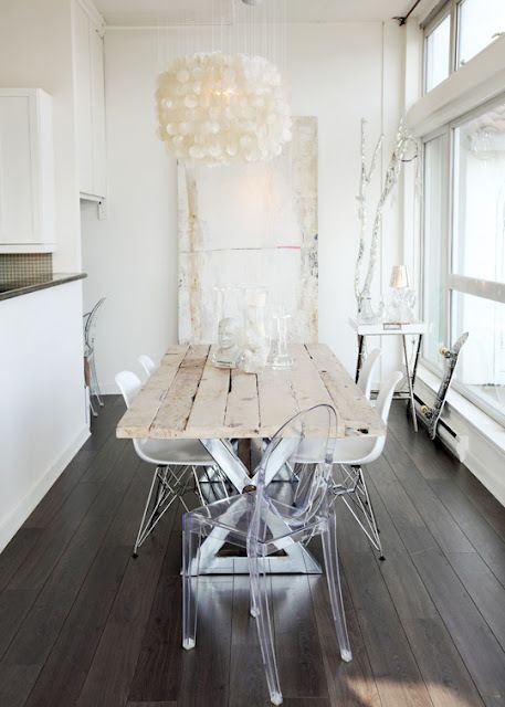 a catchy shabby chic dining space with a dining table, white Eames and ghost chairs and a seashell chandelier