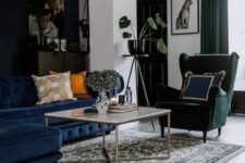 a cool living room wiht a navy sectional, a green Strandmon chair, a coffee table, a printed rug and some potted plants