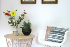 a cool nook with a side table with a wooden tabletop, a white Eames rocking chair with boho pillows, a couple of photos