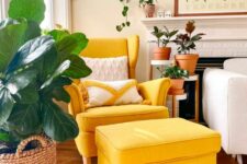 a cozy corner with a yellow Strandmon chair and an ottoman, a fireplace, potted plants and a map wall art is a lovely space