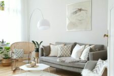 a cozy light-filled living room with a grey sofa, a rattan and a rocker chair, a hexagon coffee table and a woven pendant lamp