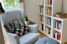 a cozy reading nook with a bookshelf, a white Strandmon chair, a grey footrest, a floor lamp and printed pillows