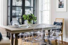 a farmhouse dining space with a black glass buffet, a stained table, ghost chairs and vintage ones, a jute rug