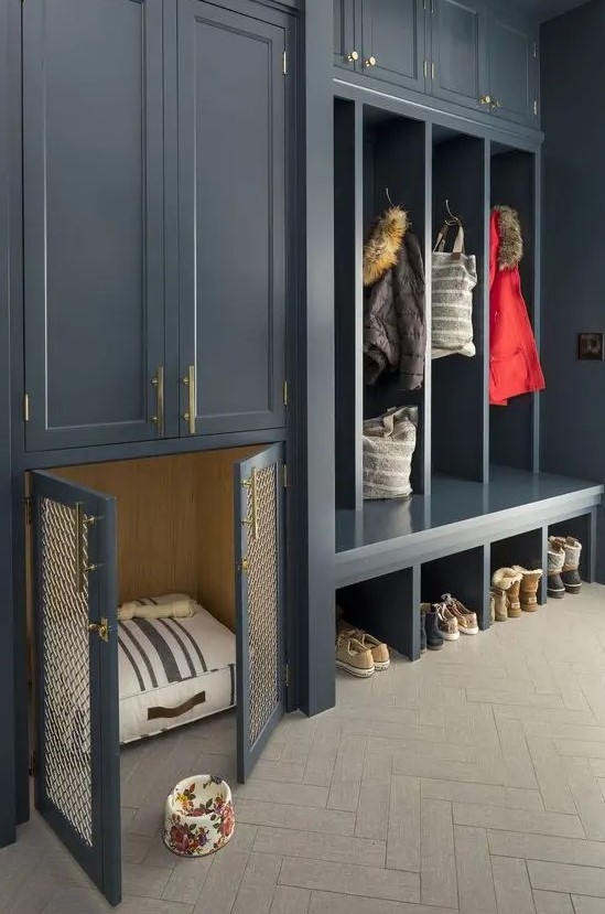 A graphite grey entryway with open and closed storage units and with a built in dog kennel with a striped mattress