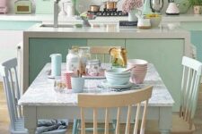 a pastel dining room with green cabinets, a grey vintage table, pastel chairs and a green pendant lamp and pastel porcelain