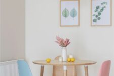 a pastel dining space with a stained round table, pastel chairs and a pink pendant lamp, a mini botanical gallery wall
