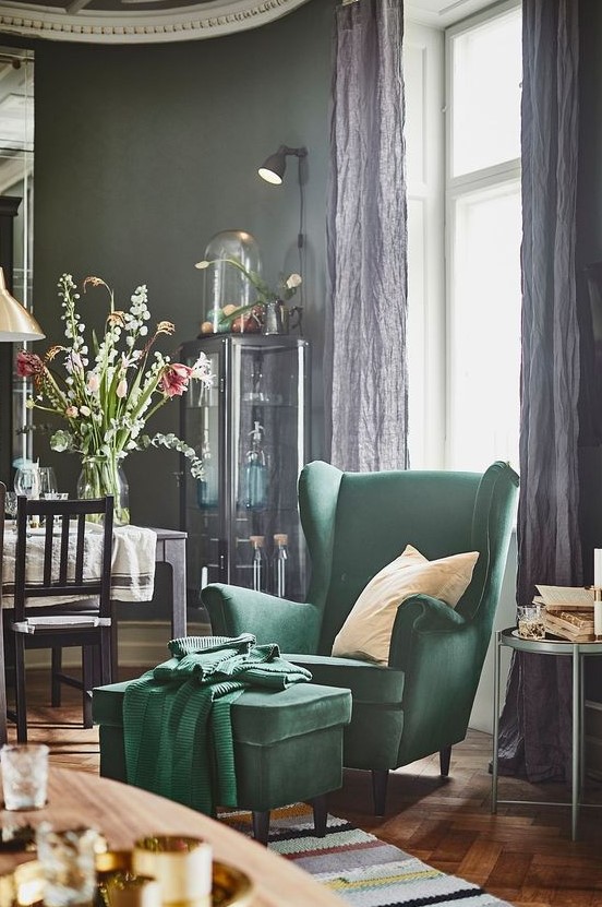 A refined vintage inspired space with a hunter green IKEA Strandmon chair and a footrest by the window to read comfortably here