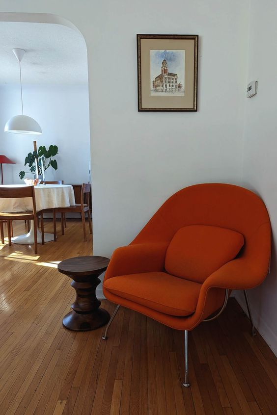 a rust-colored Wumb chair taking an awkward nook in the space is a bold and cool idea, it looks great even without an ottoman