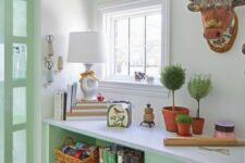 a whimsical mint-colored space with a built-in dog crate and metal baskets for storage plus lots of fun and bold decor