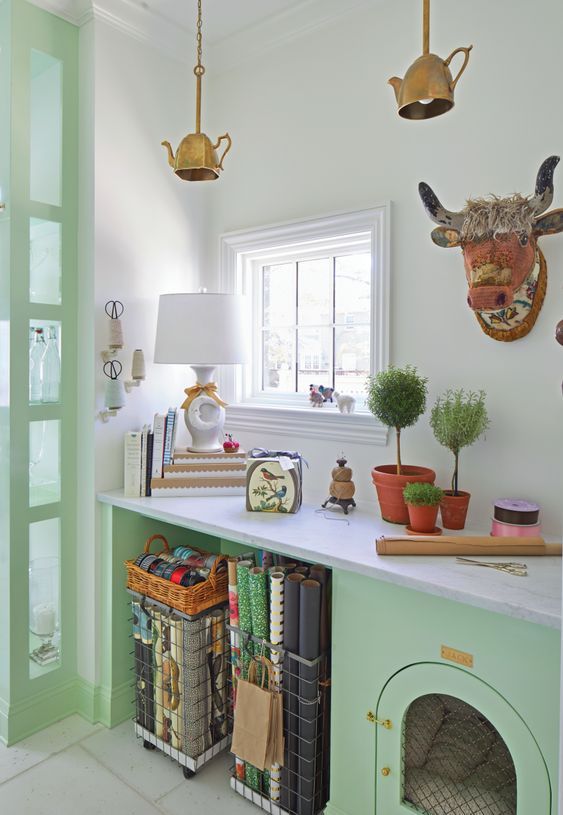 A whimsical mint colored space with a built in dog crate and metal baskets for storage plus lots of fun and bold decor