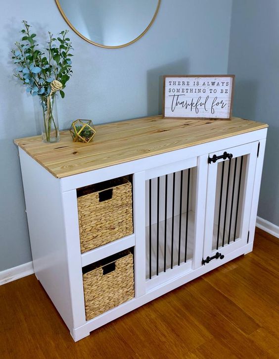 A white farmhouse cabinet with a built in crate and baskets for storage, a butcherblock countertop and some decor
