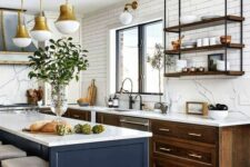 04 a chic modern kitchen with stained cabinets, a navy kitchen island, white countertops and a backsplash, suspended shelves and brass pendant lamps