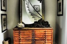 07 a vintage stained file cabinet with a large mirror in a chic frame and some unusual decor will make your entryway wow