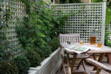 08 a small and cozy backyard with a deck, a simple wooden outdoor furniture set, potted greenery and climbing plants is very cozy