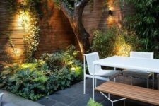 10 a contemporary townhouse garden with stone tiles, minimalist furniture of wood and metal, lush textural greenery and a tree growing