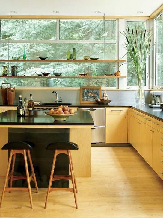 A light stained modern kitchen with suspended shelves instead of upper cabinets and a large contrasting kitchen island