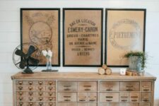 11 a light-stained card cabinet is a beautiful vintage storage unit, rustic vintage art over it and greenery in a bucket add interest to it