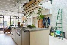 12 a modern light-stained plywood kitchen with suspended shelves, a skylight and lots of greenery