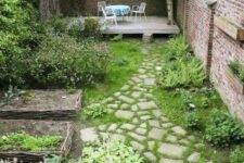 12 a small walled garden with a grene lawn, some flower beds, greenery and shrubs plus a couple of trees