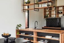 17 a stylish kitchen in black and light-stained wood, with open cabinets and suspended shelves, a storage kitchen island and potted greenery