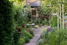 19 a cute narrow garden with a tile pathway, greenery and blooms is a dreamy space with a dining set