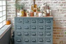 21 a vintage grey card cabinet with potted plants, dried herbs and candles is a lovely plant stand and storage unit in one
