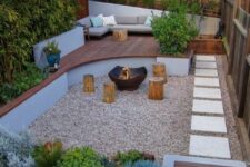 23 a small and welcoming backyard with a fire pit zone and tree stumps with growing plants and trees, with a raised sitting zone with a sofa