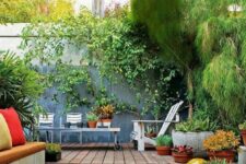 24 a small backyard with pebbles and a sitting zone with a built-in bench, lots of potted plants, a living wall and modern garden furniture
