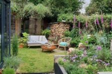 26 a small and cozy garden with a flower bed, some bright blooms in pots and not only, a lawn and some garden furniture