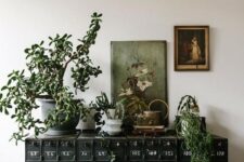 28 a gorgeous black vintage card cabinet with potted plants and vintage artwork will instantly turn your space in a refined vintage one