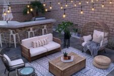 34 a small paved patio turned into an entertainment zone, with a bar, a sitting zone with rattan furniture and string lights is very cozy