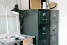 36 a vintage industrial home office with a metal desk and a plywood chair, a black card cabinet for storage, a table lamp and some greenery