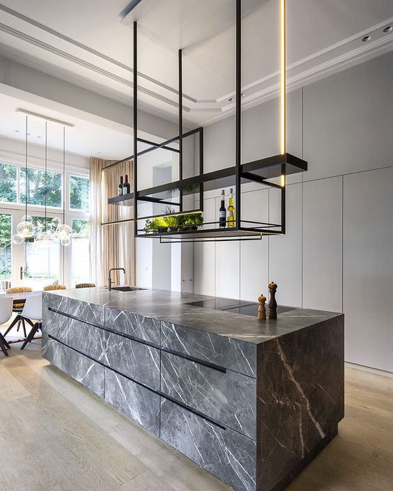 A refined minimalist kitchen with sleek white cabinetry, a grey marble kitchen island, suspended shelves and built in lights