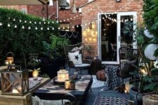39 a small yet stylish backyard space with a wooden deck, lots of greenery, lights, candles and simple wooden furniture