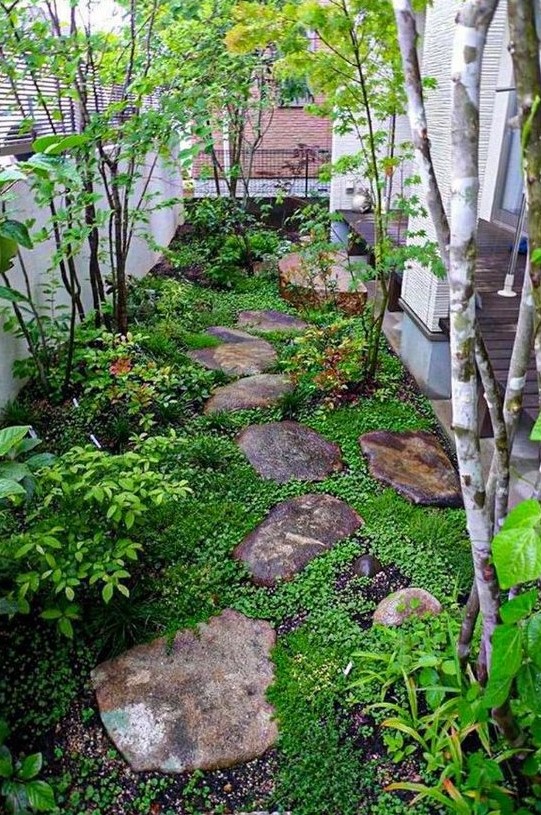 a small Japanese-inspired garden with rocks as pavements, greenery, shrubs and a couple of trees is very peaceful