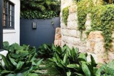 46 a small side modern garden nook with greenery, some lush tropical shrubs on both sides of the pavement