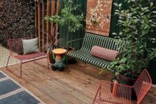 59 a welcoming deck with pretty and bold metal outdoor furniture, with some potted plants and a dark green fence