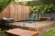 61 a tropical outdoor space with greenery, a rich-stained deck and steps and a small pool with a bench and a pouf