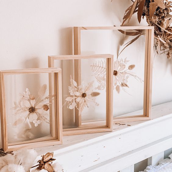A beautiful home decoration of dried white blooms and leaves in light stained frames is a cool idea for a mantel