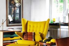 a bold space with a colorful storage unit, a yellow Papa Bear chair and a footrest, a side table and a lamp