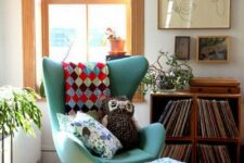 a bright boho nook with crates with vinyl, some artwork, a green Egg chair and a footrest, potted plants is cool